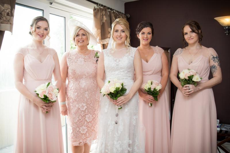 bridesmaids with bride holding flowers with soft makeup
