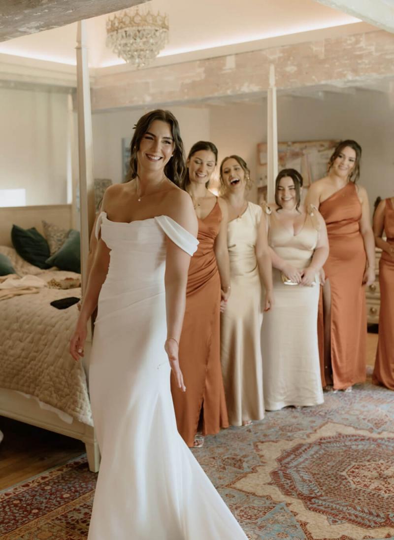 Bridesmaids laughing together with bride