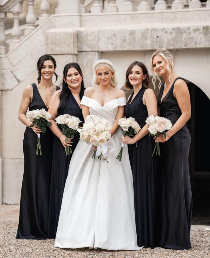 Bridesmaids in black dresses with coordinated champagne makeup looks