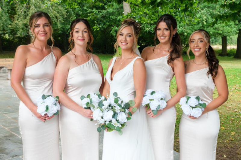Bridesmaids holding bouquets showing coordinated makeup and flowers