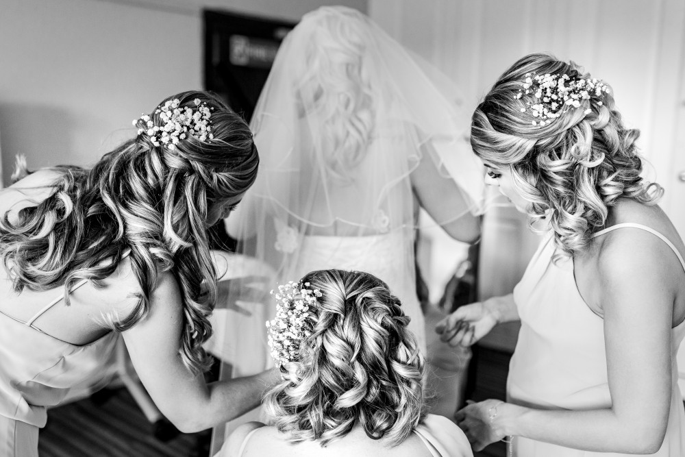 The bridesmaids all coming together to help the bride perfect her bridal look! The wedding morning is always a time when everybody pulls together. And I loved creating these beautiful shining curls for this bridal party. - Make Me Bridal Artist: Bridal Hair in Hampshire. Photography by: Lloyd Richard Photography. #glamorous #curls #gettingready #bridalhair #blonde