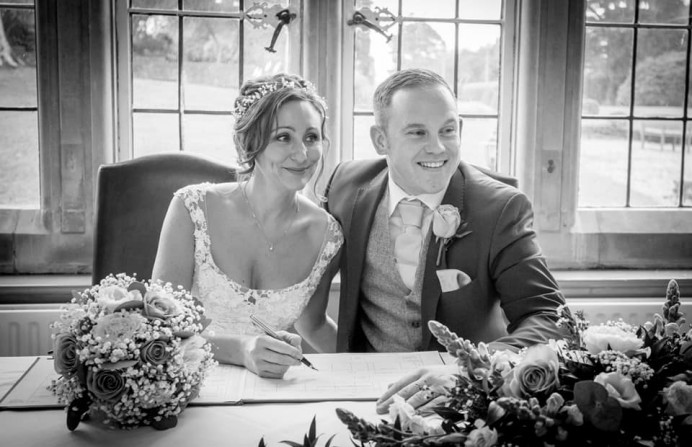 The bride and groom signing the register. - Make Me Bridal Artist: Bridal Hair in Hampshire. Photography by: Kevin Drake Photography. #weddingmorning #bridalmakeup #bridalhair