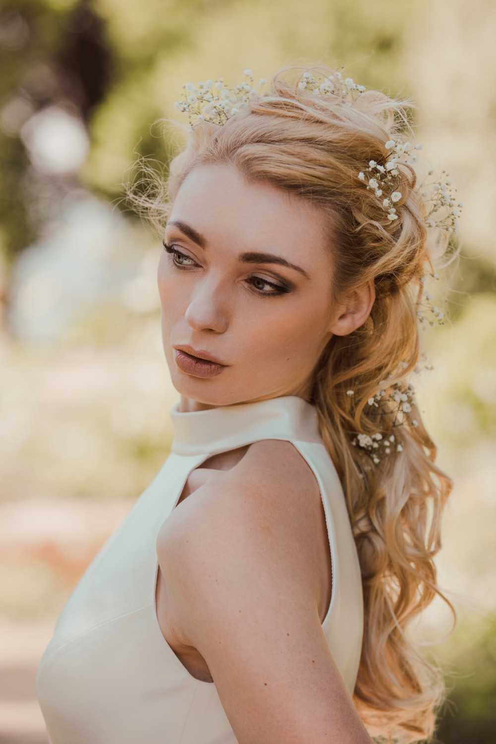 Stunning Kat modelling a La novia gown in the grounds on Lauriston Castle, Edinburgh - Make Me Bridal Artist: V M hair and makeup. Photography by: Ian Vincent. #bridalmakeup #bridalhair #flowersinherhair #elegant #romantichairup #smokeyeye #summerwedding